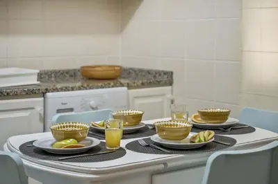 a kitchen with a table with plates and glasses of orange juice at Apartamento Netos - By WeHost in Funchal