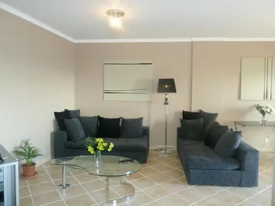 a living room with two couches and a glass table at Oceanic Apartment in Caniço