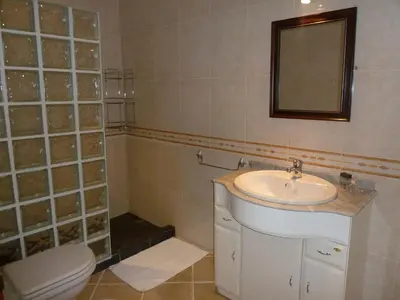 a bathroom with a sink and a toilet and a mirror at Oceanic Apartment in Caniço