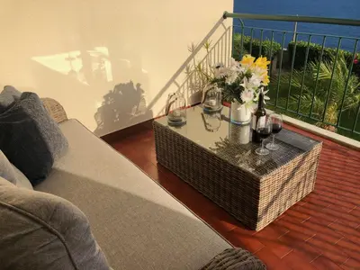 a living room with a couch and a table with wine glasses at Oceanic Apartment in Caniço