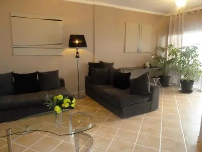 a living room with two couches and a glass table at Oceanic Apartment in Caniço