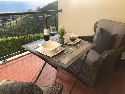 a table with two glasses of wine on a balcony at Oceanic Apartment in Caniço