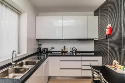 a kitchen with white cabinets and a sink at Pink House - Tabua (Ribeira Brava) in Ribeira Brava