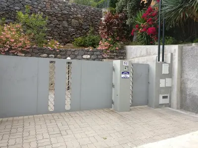 a white fence with a gate and a stone wall at Pink House - Tabua (Ribeira Brava) in Ribeira Brava
