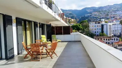 a balcony with a table and chairs on a building at Top Floor in City Center Funchal in Funchal