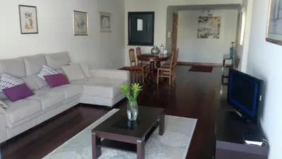 a living room with a white couch and a tv at Top Floor in City Center Funchal in Funchal