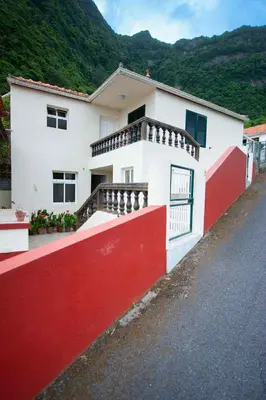 a white and red house with a red wall at Casa Reis in Santana