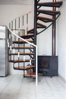 a spiral staircase in a room with a fireplace at Casa Reis in Santana