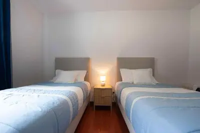 two beds in a room with a lamp on a table at Casa Reis in Santana