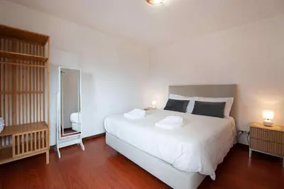 a bedroom with a large white bed with two lamps at Casa Reis in Santana