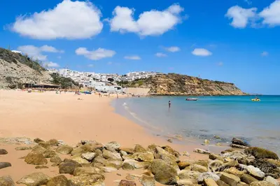 a beach with a bunch of rocks in the water at Casa Aromas do Mar, Burgau in Burgau