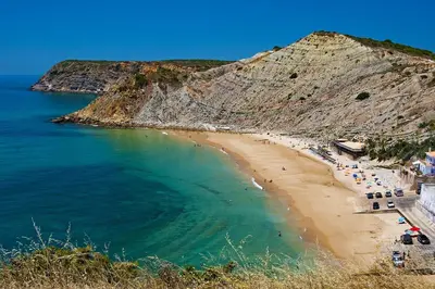 a beach with a group of people in the water at Casa Aromas do Mar, Burgau in Burgau
