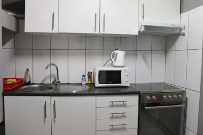 a small kitchen with a sink and a microwave at Casa reizinho in Santana
