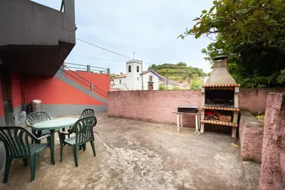 a patio with a table and chairs and a grill at Casa reizinho in Santana