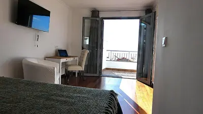 a room with a bed and a desk with a laptop at Madeira Serenity Cottage in Funchal