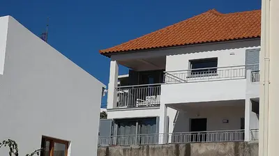 a white apartment building with a red roof at Madeira Serenity Cottage in Funchal