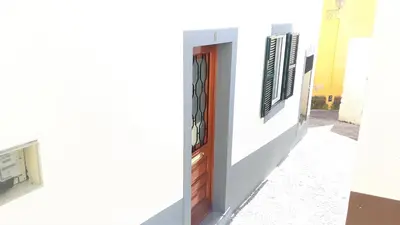 a white building with a brown door and windows at Casa da Avó Irene in Funchal