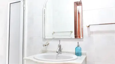 a white bathroom with a sink and a mirror at Casa da Avó Irene in Funchal