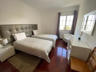 a bedroom with two beds and a desk and window at Santa Luzia Apartment in Funchal