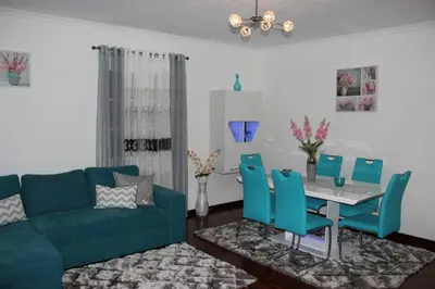a living room with a blue couch and a table and chairs at Santa Luzia Apartment in Funchal