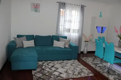 a living room with a blue couch and a table at Santa Luzia Apartment in Funchal