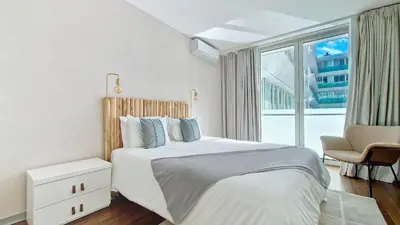 a white bedroom with a bed and a large window at Upscales by LovelyStay - private parking in Funchal