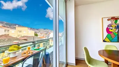 a room with a table and a balcony with a view at Upscales by LovelyStay - private parking in Funchal