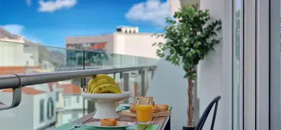 a bowl of bananas on a table on a balcony at Upscales by LovelyStay - private parking in Funchal