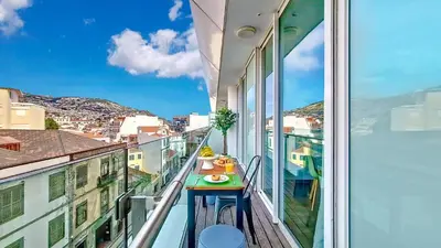 a balcony with a table and a view of a city at Upscales by LovelyStay - private parking in Funchal
