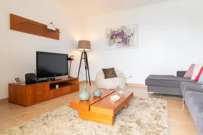 a living room with a couch and a tv at The Blue Pearl-Villa Paul in Calheta