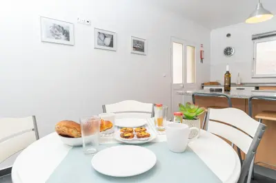 a white table with plates of food on it at The Blue Pearl-Villa Paul in Calheta