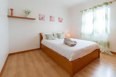 a bedroom with a bed with white sheets and a window at The Blue Pearl-Villa Paul in Calheta