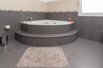 a bath tub in a bathroom with a rug at The Blue Pearl-Villa Paul in Calheta