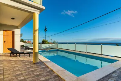a swimming pool on the balcony of a house at The Blue Pearl-Villa Paul in Calheta
