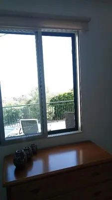 a room with two windows and a wooden dresser at Vivenda Cabral in Funchal