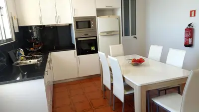 a kitchen with a white table and a white refrigerator at Vivenda Cabral in Funchal