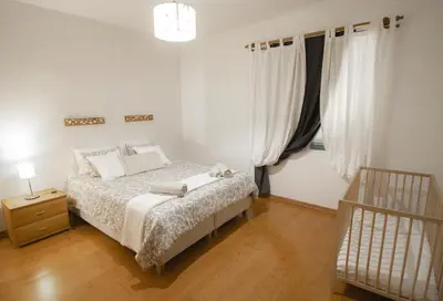 a white bedroom with a bed and a window at Slowing Villas - Villa Oceano in Porto Santo