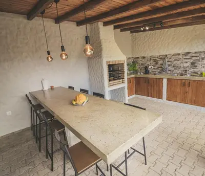a large kitchen with a large wooden table with chairs at Slowing Villas - Villa Oceano in Porto Santo