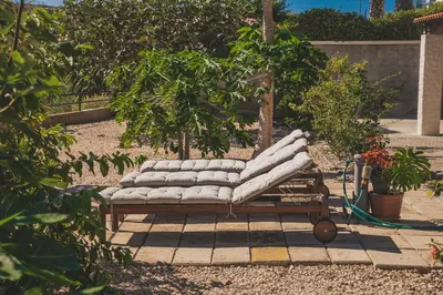 a pile of pillows on a bench in a garden at Slowing Villas - Villa Oceano in Porto Santo