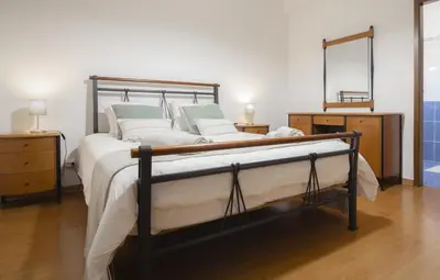 a bedroom with a bed and a mirror on the wall at Slowing Villas - Villa Oceano in Porto Santo
