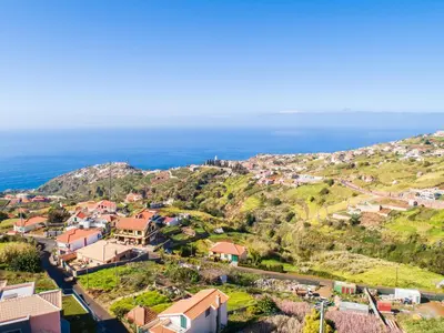 an aerial view of a village on a hill with the ocean at Casa Por Do Sol in Ponta do Sol