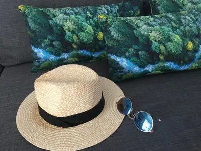 a straw hat and sunglasses sitting on a couch at Apart. Madeira 4 you in Funchal