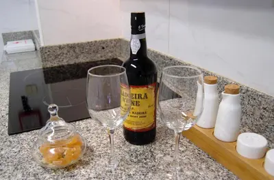 a bottle of wine sitting on a counter with two wine glasses at Apart. Madeira 4 you in Funchal