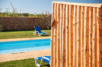a fence with two chairs next to a swimming pool at Tonel Apartamentos Turisticos in Sagres