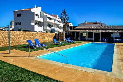 a swimming pool in front of a house at Tonel Apartamentos Turisticos in Sagres