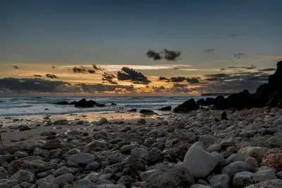 a large group of rocks on a beach at sunset at Tonel Apartamentos Turisticos in Sagres