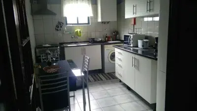a kitchen with white cabinets and a table in it at House Joel & Sónia in Funchal