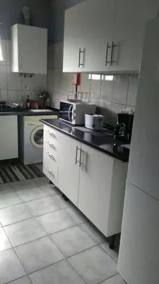 a kitchen with white cabinets and white appliances at House Joel & Sónia in Funchal