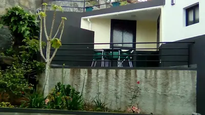 a house with a balcony with a table and chairs at House Joel & Sónia in Funchal