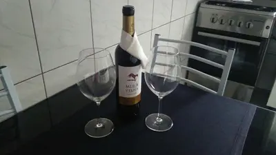 a bottle of wine and two wine glasses on a counter at House Joel & Sónia in Funchal